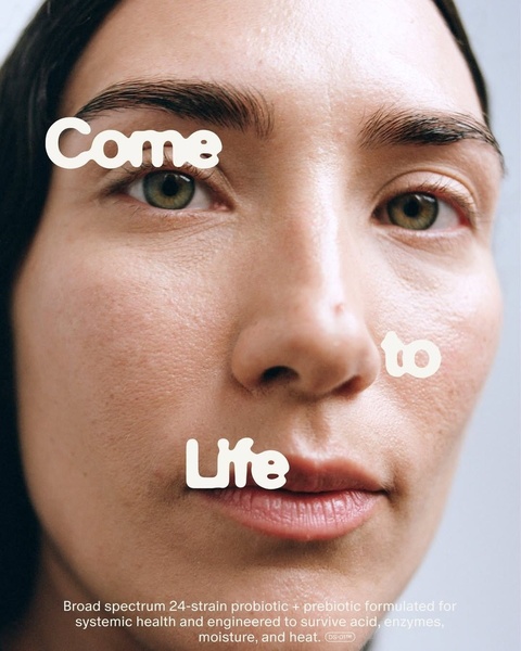 A close-up portrait of a woman with clean, natural skin, overlaid with bold, playful typography promoting a 24-strain probiotic and prebiotic formula.